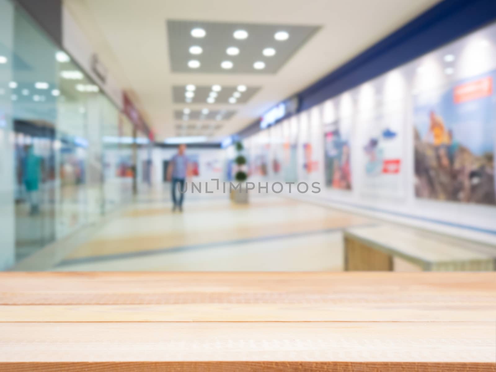 Light wooden board empty table in front of blurred shopping mall - can be used for display or montage your products. Mockup for display of product.