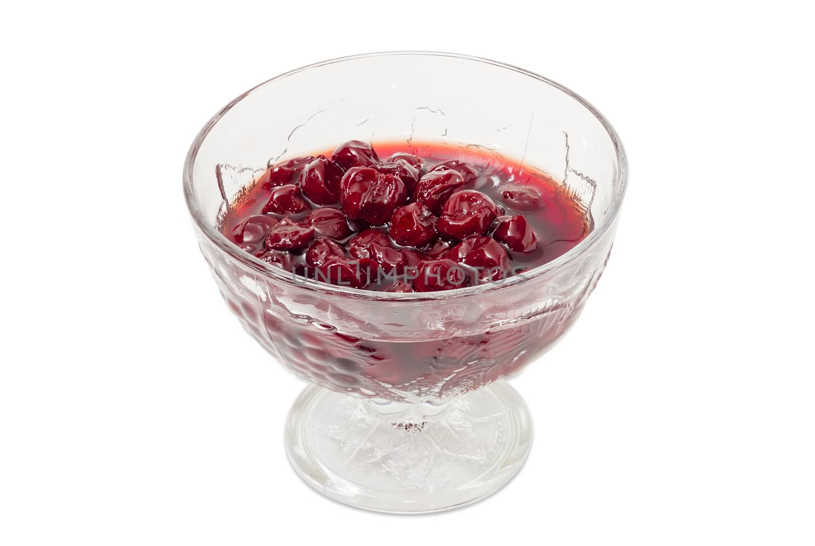 Cherry jam with whole fruits in the glass dessert stem bowl on a light background
