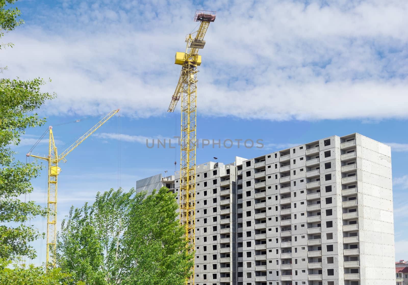 Two tower cranes against of multi-story residential building con by anmbph