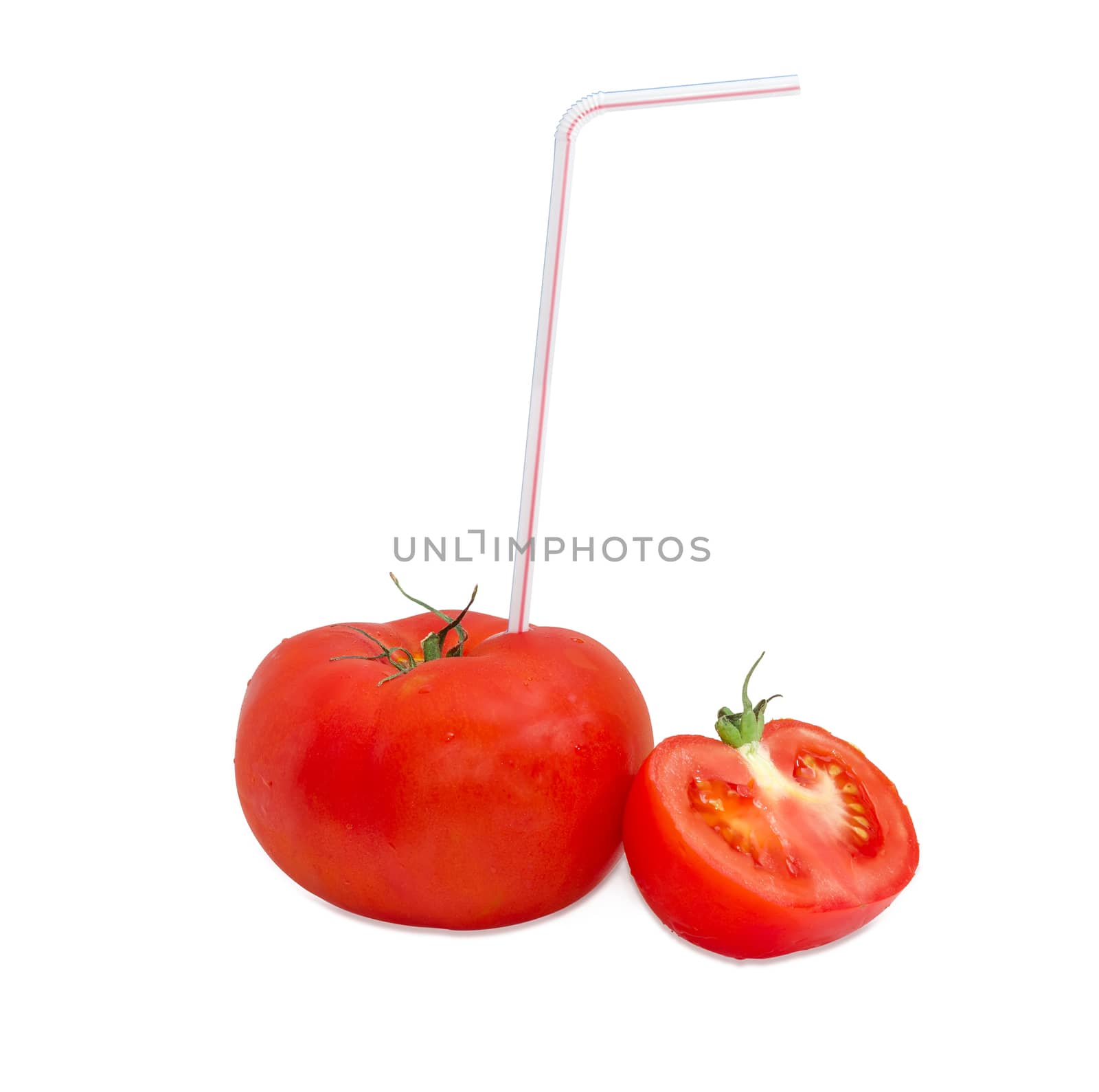 Big fresh ripe tomato and bendable drinking straw inserted into it and half of other tomato on a light background
