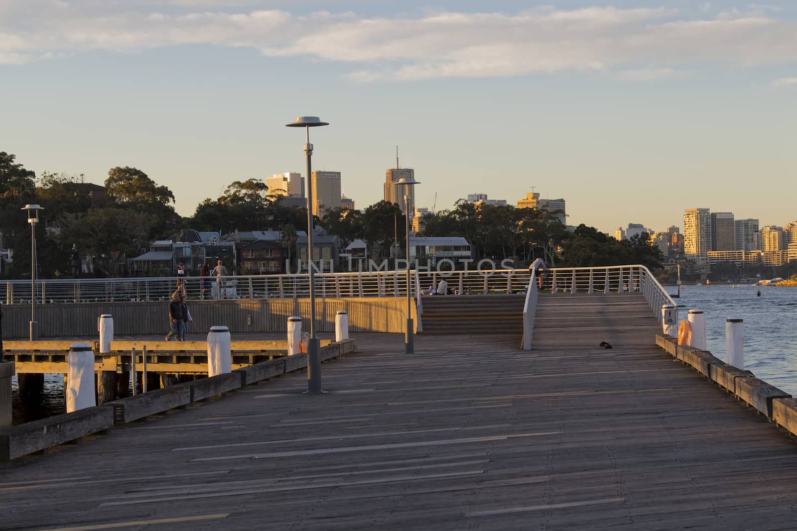 Sydney, Australia - June 24, 2017: Fishermen at dusk on Darling Island Wharf in Pyrmont, Sydney Australia with the CBD skyscrapers in the background.