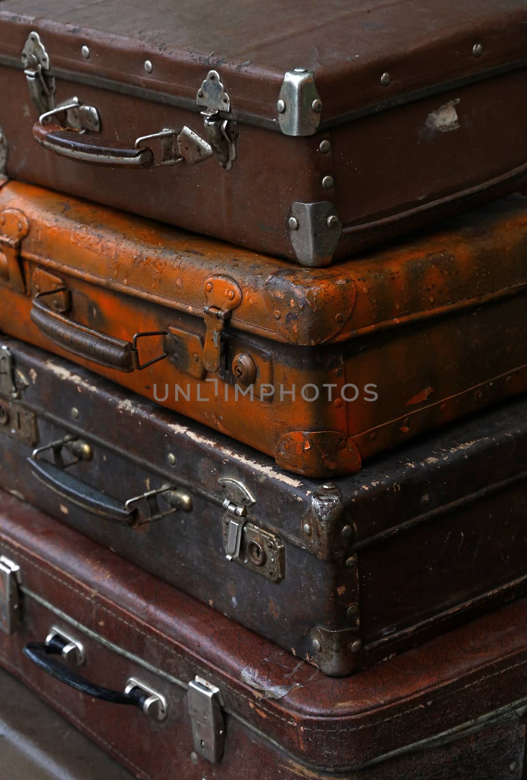 Stack of four old vintage antique grunge travel luggage brown leather suitcase trunks, close up, high angle side view