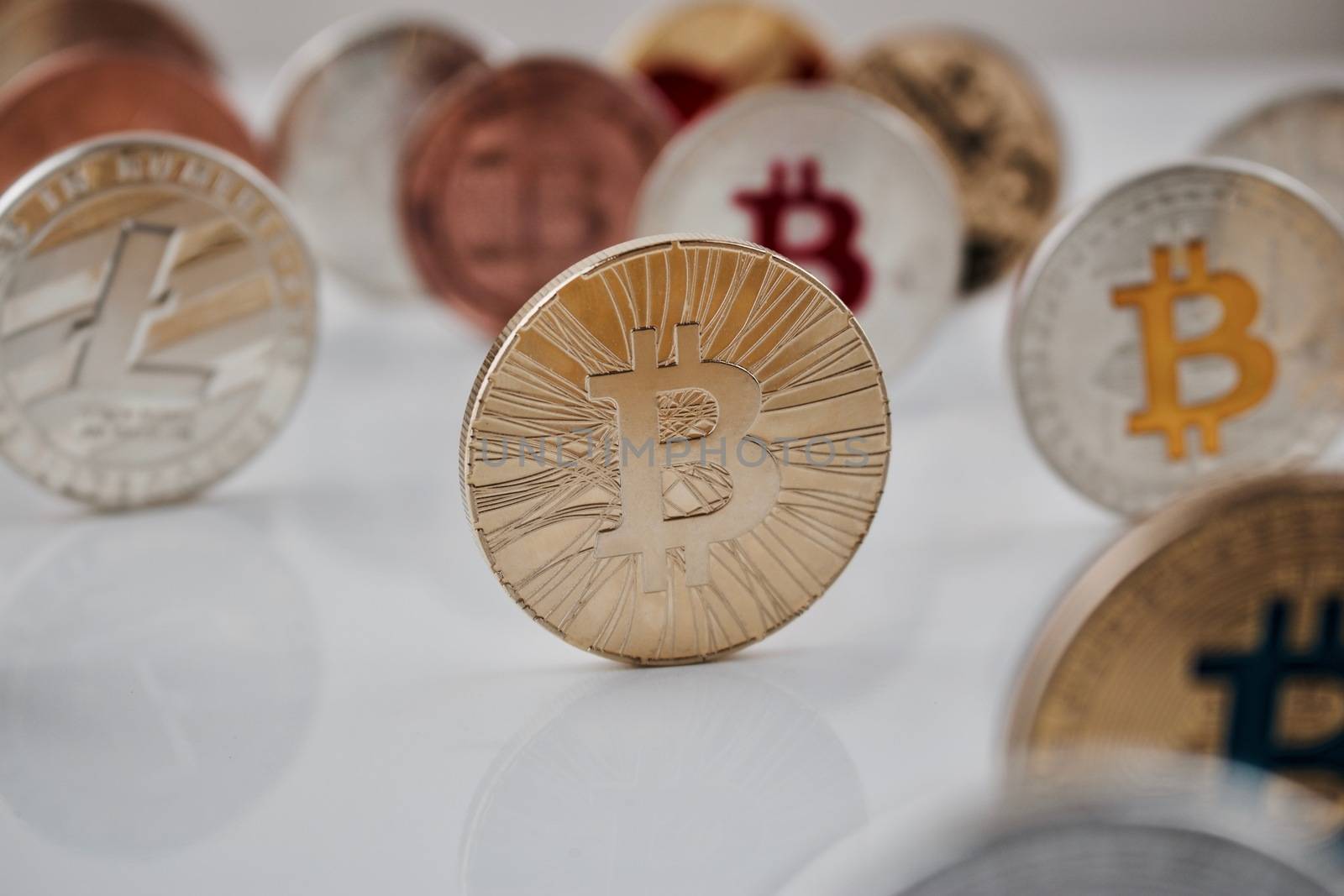 Digital currency physical gold bitcoin coin near Litecoin and colorful bitcoins.