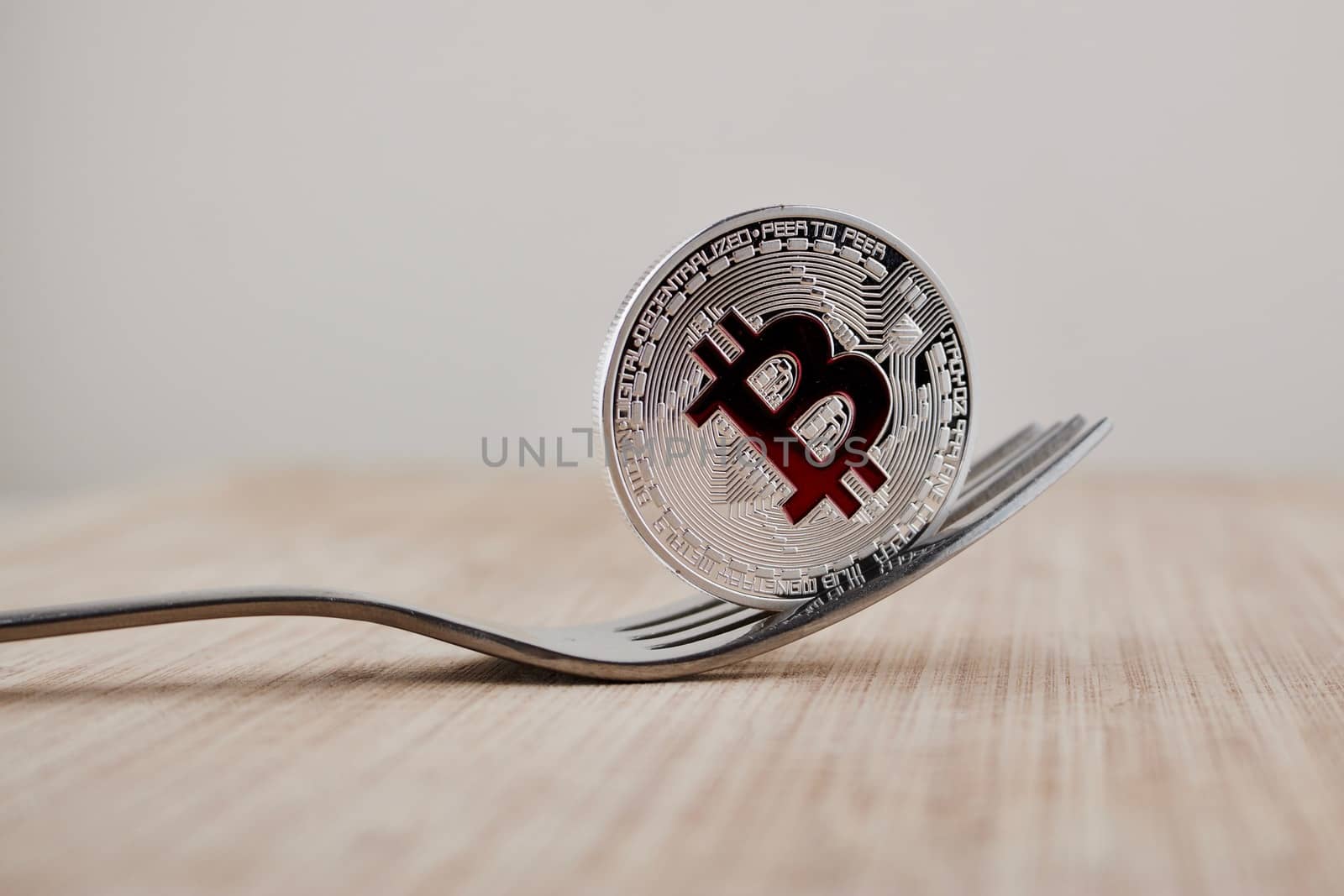 Cryptocurrency physical silver bitcoin coin with red sign on the wooden board.