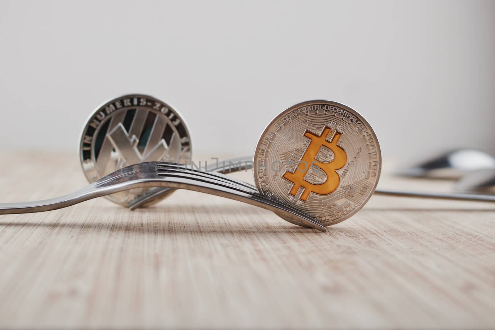 Cryptocurrency physical silver bitcoin coin near litecoin and fork.