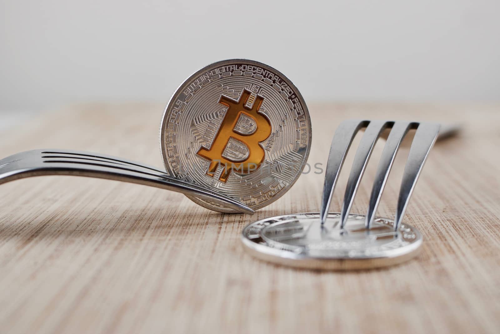 Digital currency physical silver bitcoin coin and litecoin on wooden board.