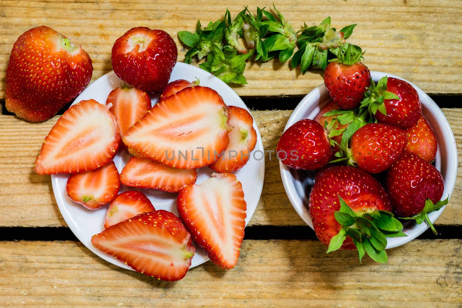 Delicious strawberry in home cooking on wooden table, black background.