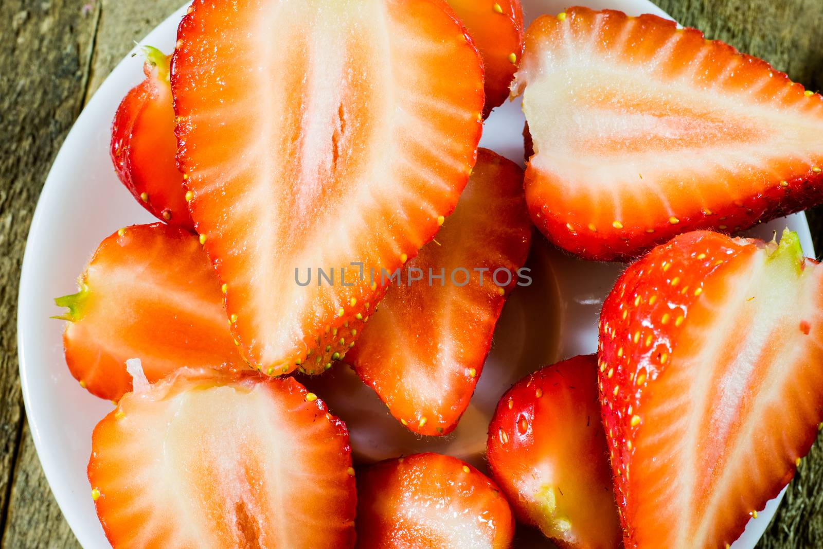 Delicious strawberry in home cooking on wooden table, black background.