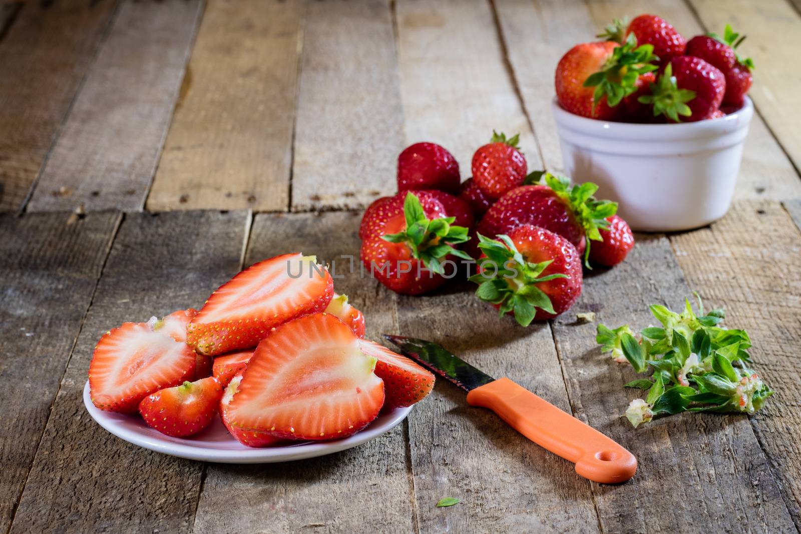 Delicious strawberry in home cooking on wooden table, black background.