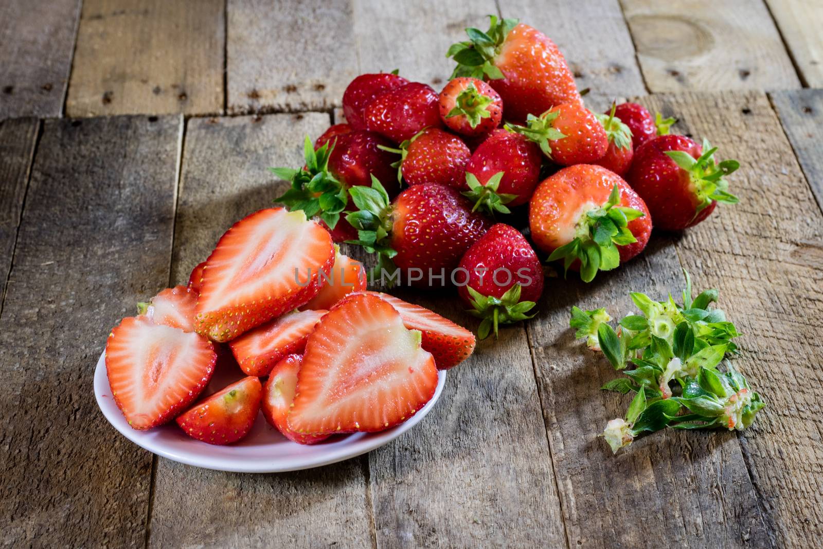 Delicious strawberry in home cooking on wooden table, black background.