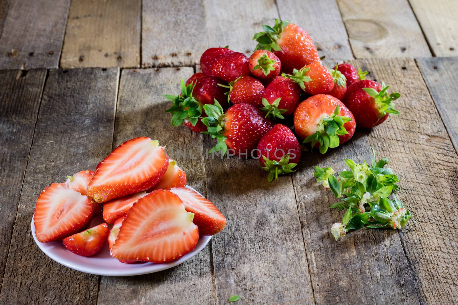 Delicious strawberry in home cooking on wooden table, black background.