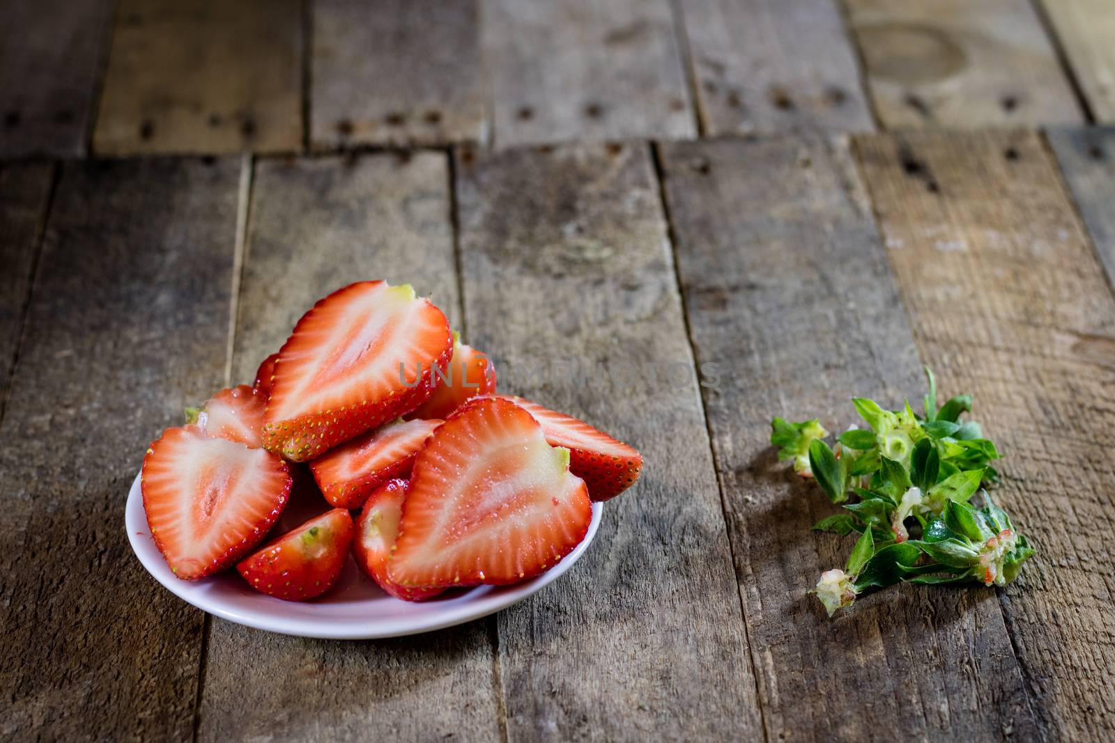 Delicious strawberry in home cooking on wooden table, black background.