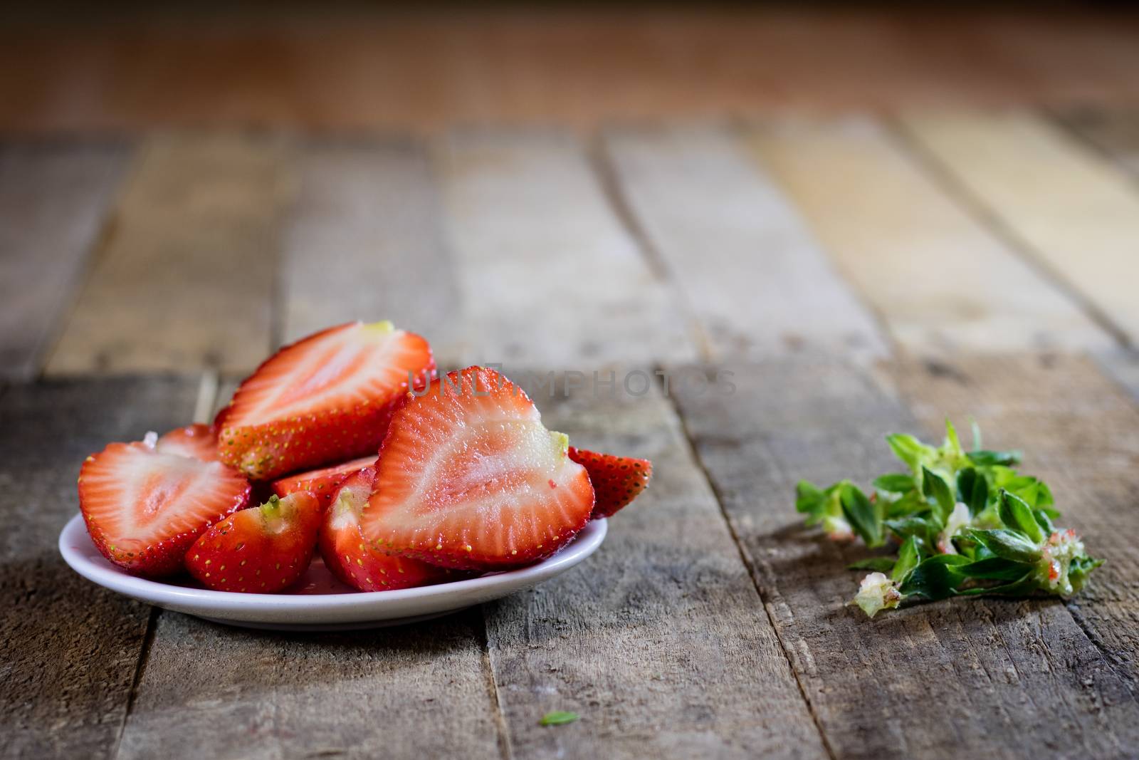 Delicious strawberry in home cooking on wooden table, black background.