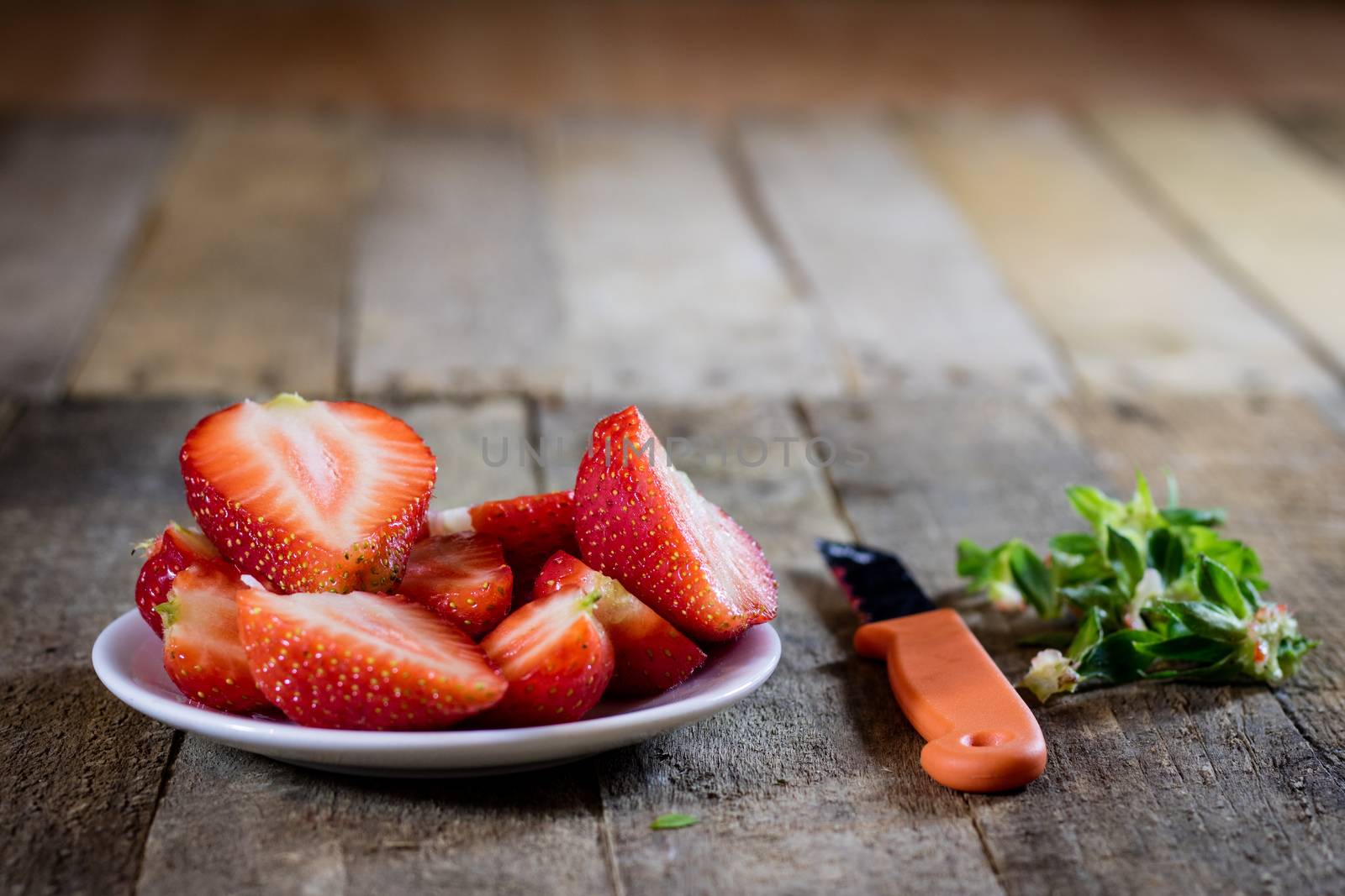 Delicious strawberry in home cooking on wooden table, black background.