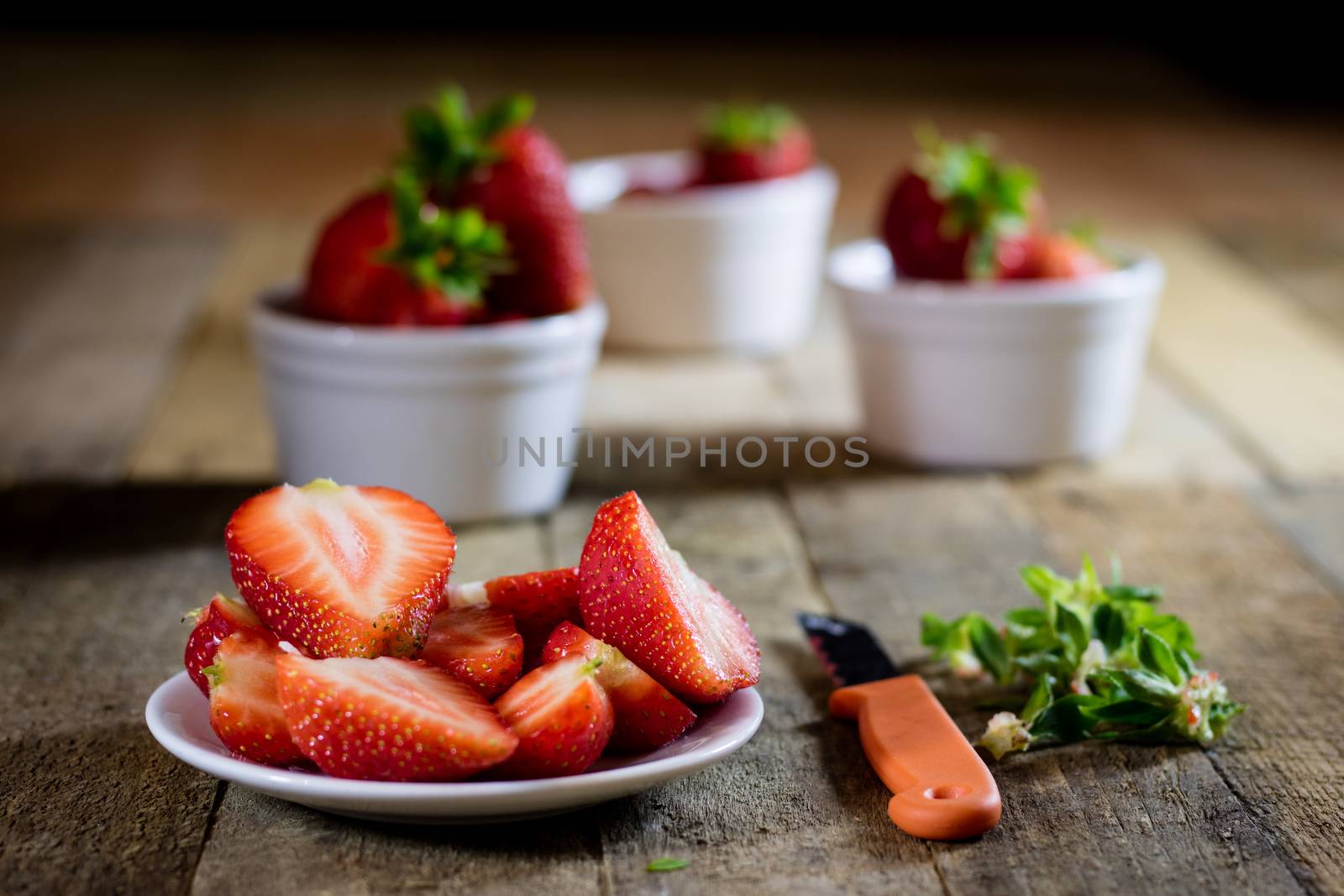 Delicious strawberry in home cooking on wooden table, black background.