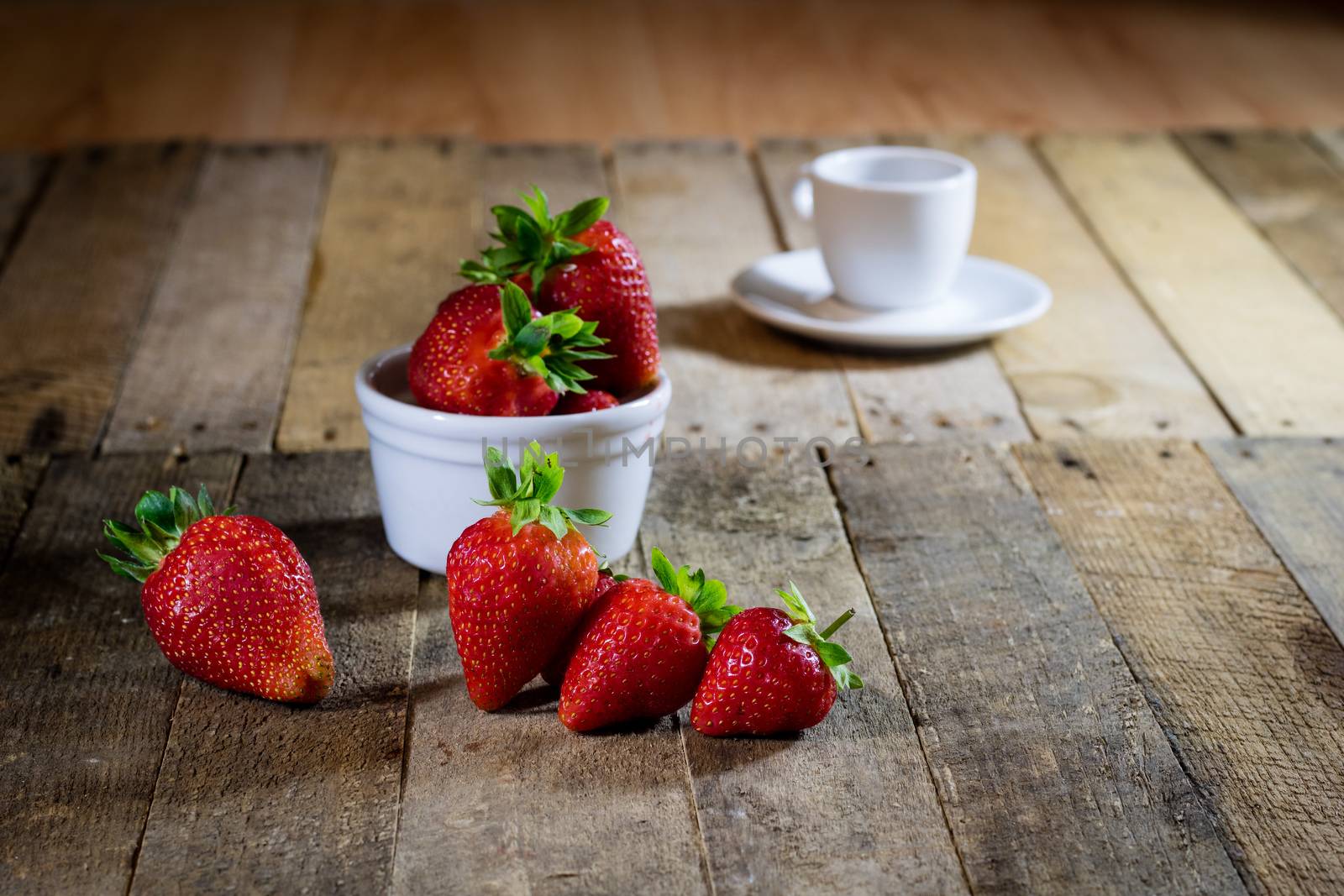 Delicious strawberry in home cooking on wooden table, black background.