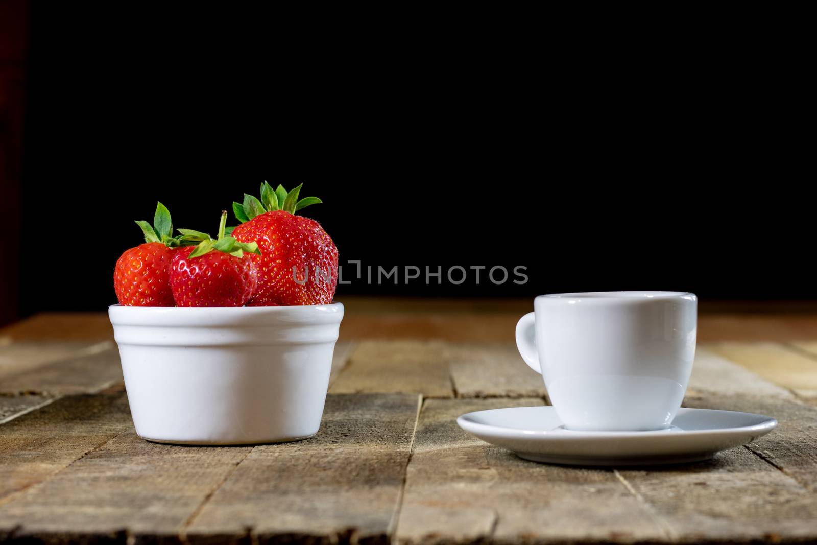 Delicious strawberry in home cooking on wooden table, black background.