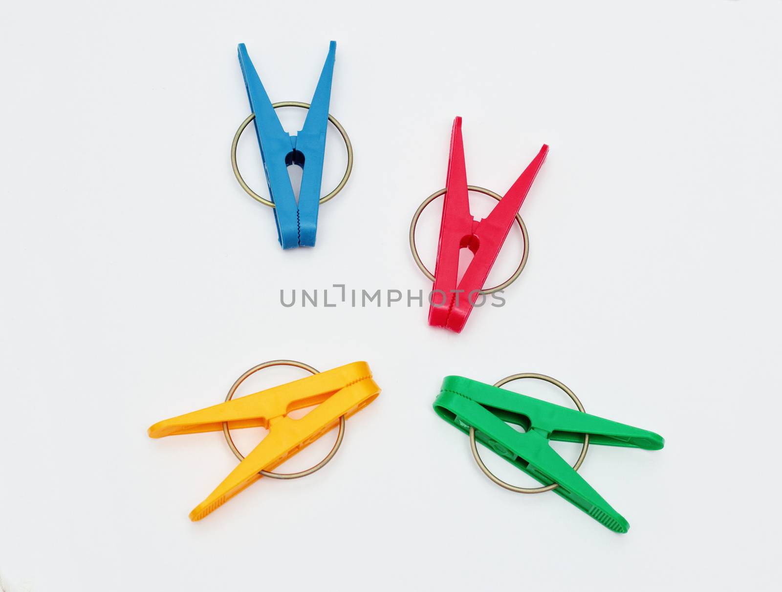 Four plastic clothes pegs isolated on white background.