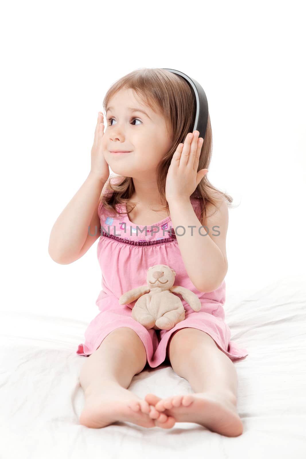 the little girl listens to music in earphones