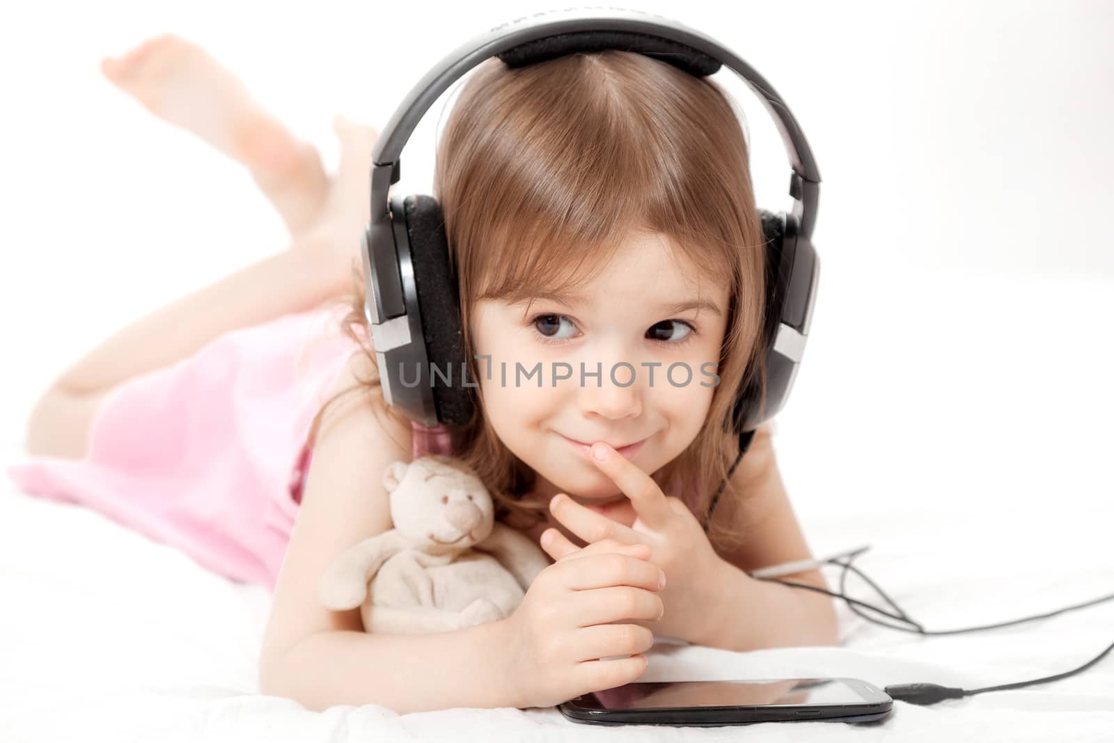 the little girl listens to music in earphones