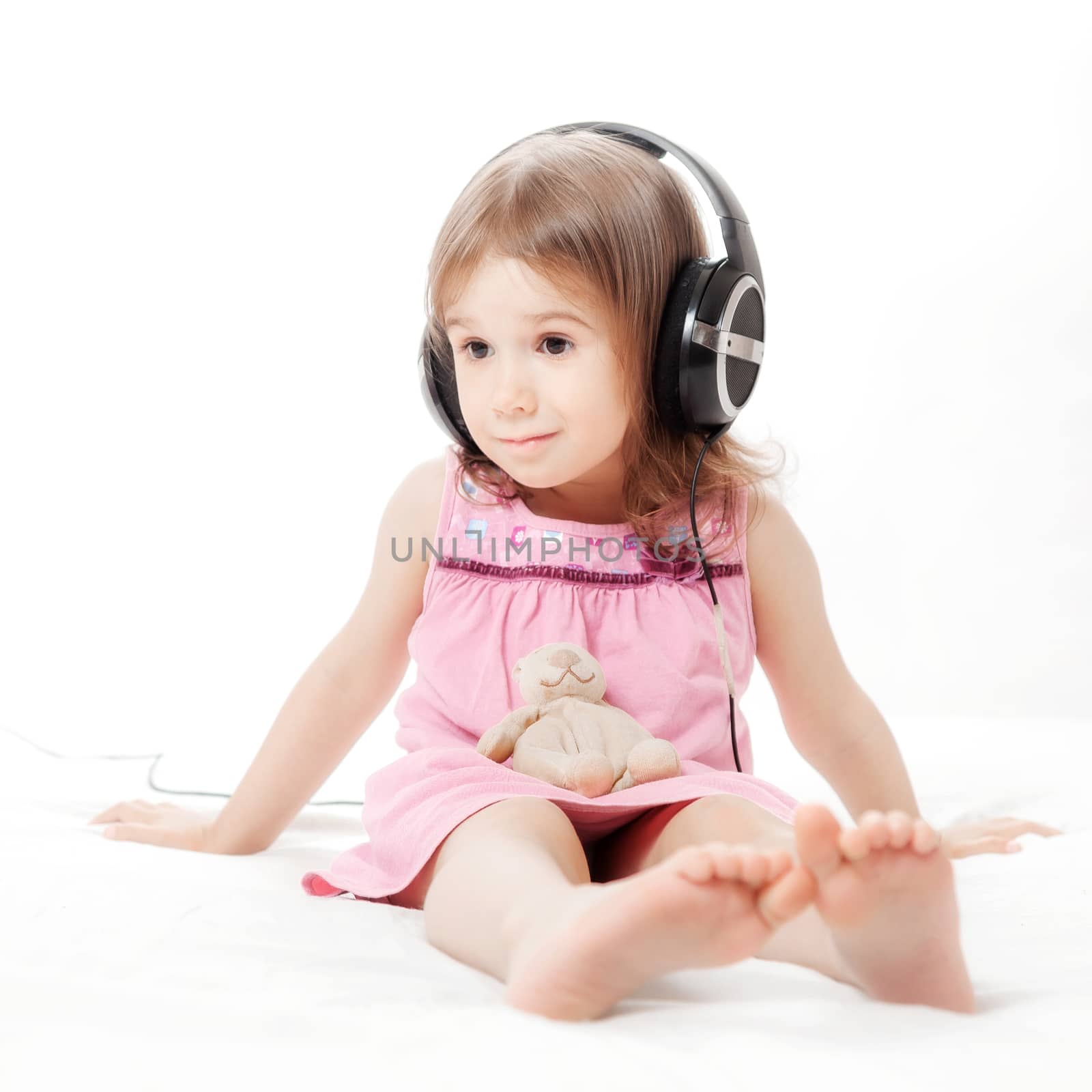 the little girl listens to music in earphones