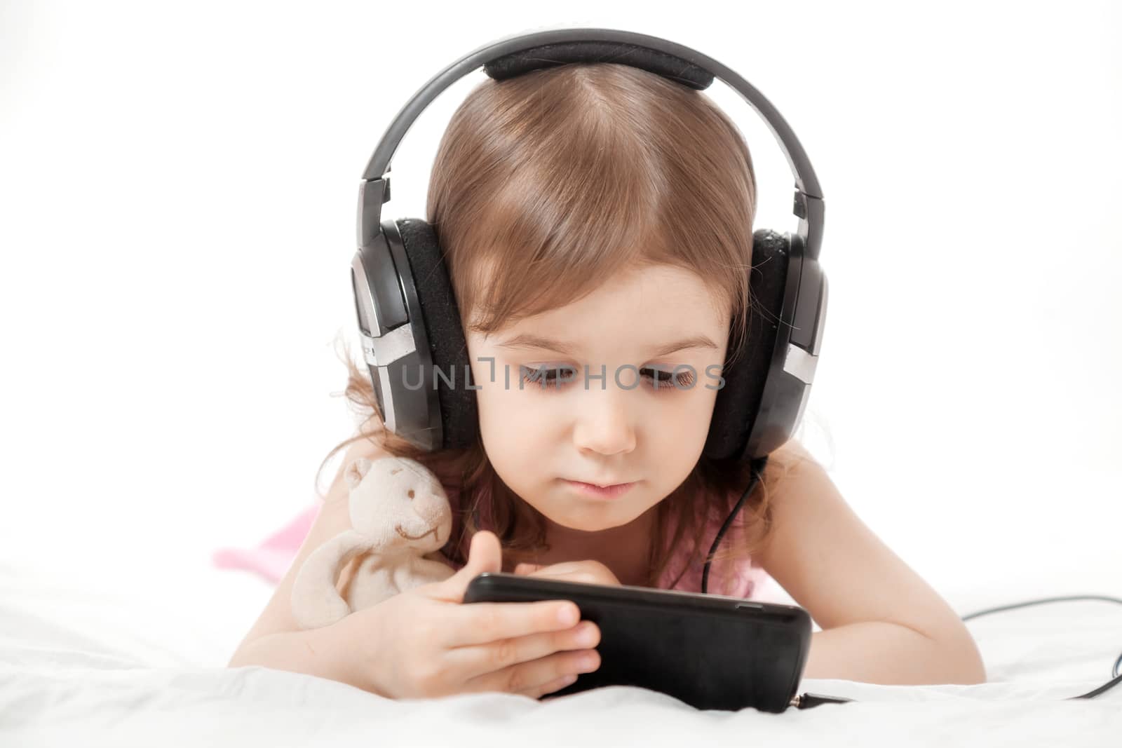 the little girl listens to music in earphones