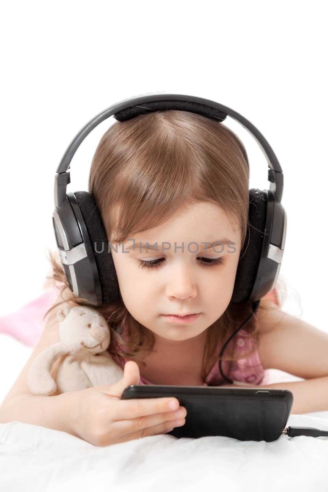 the little girl listens to music in earphones