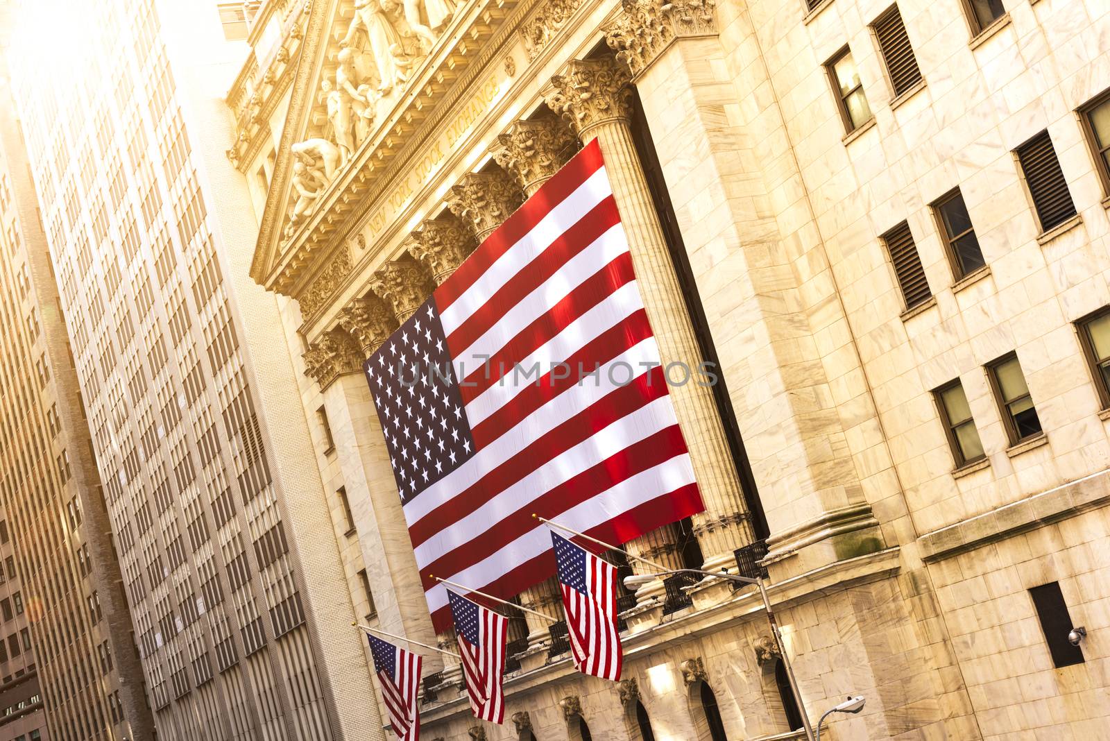 Famous Wall street and the building in New York, New York Stock Exchange with patriot flag