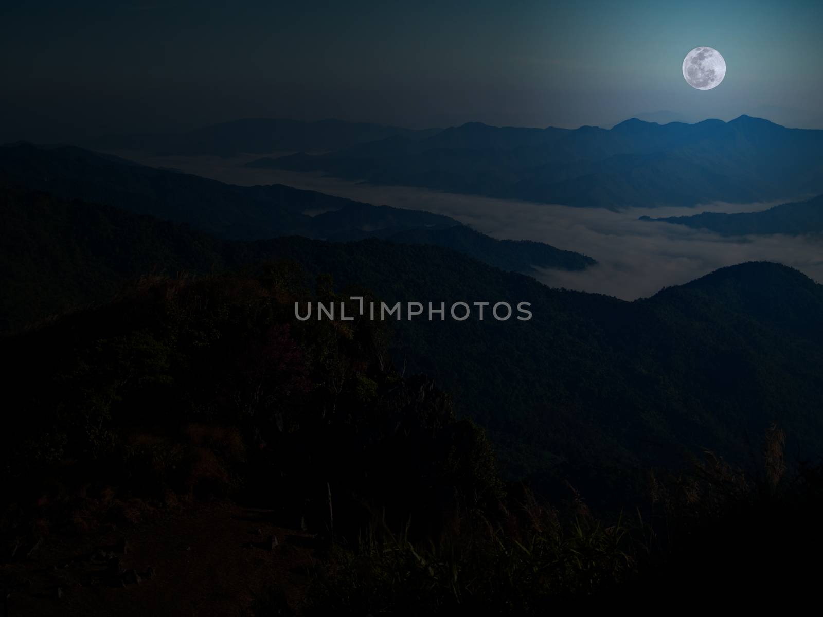 Mountain and mist with full moon at midnight.