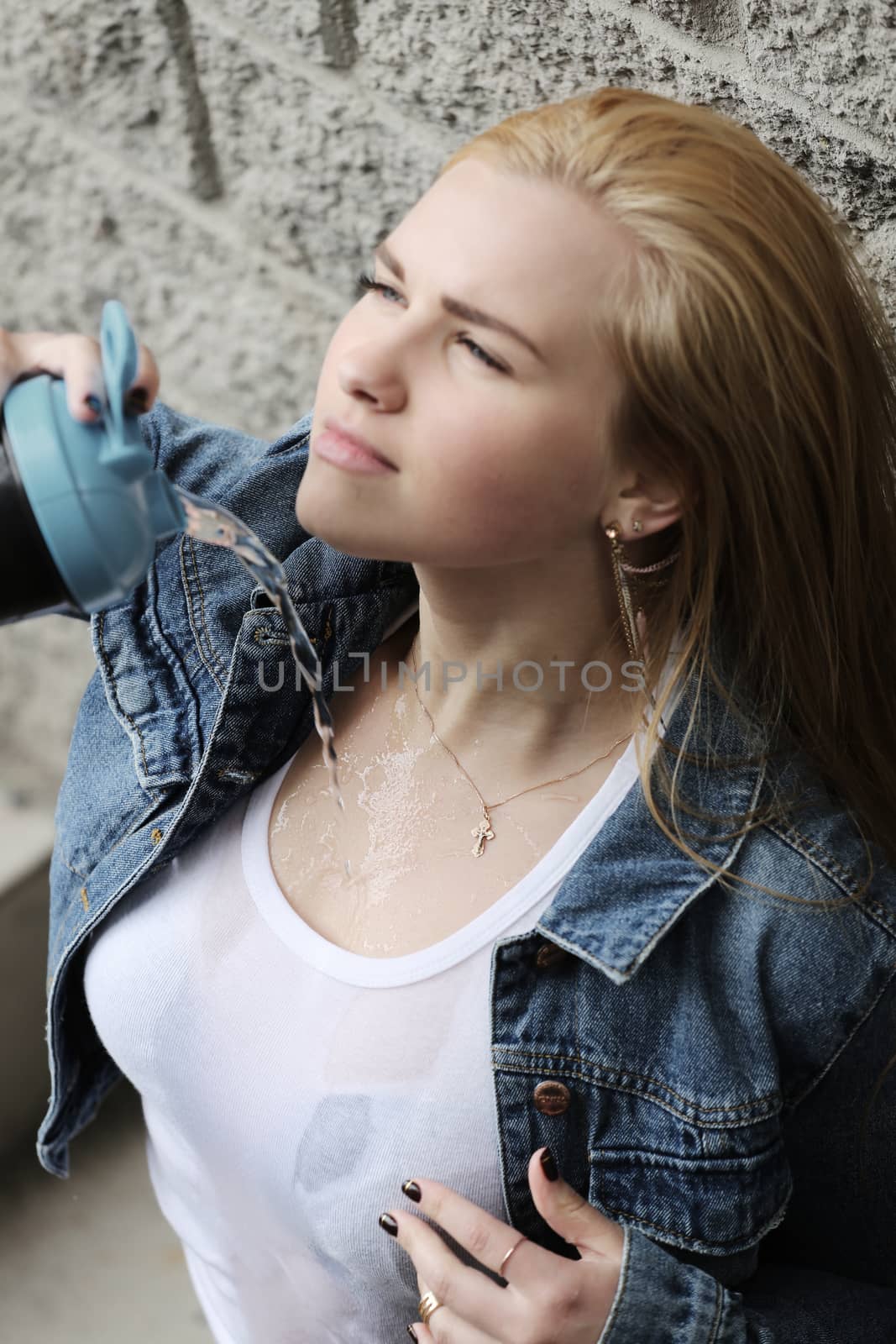 Woman spilling water on herself, urban style sexy portrait