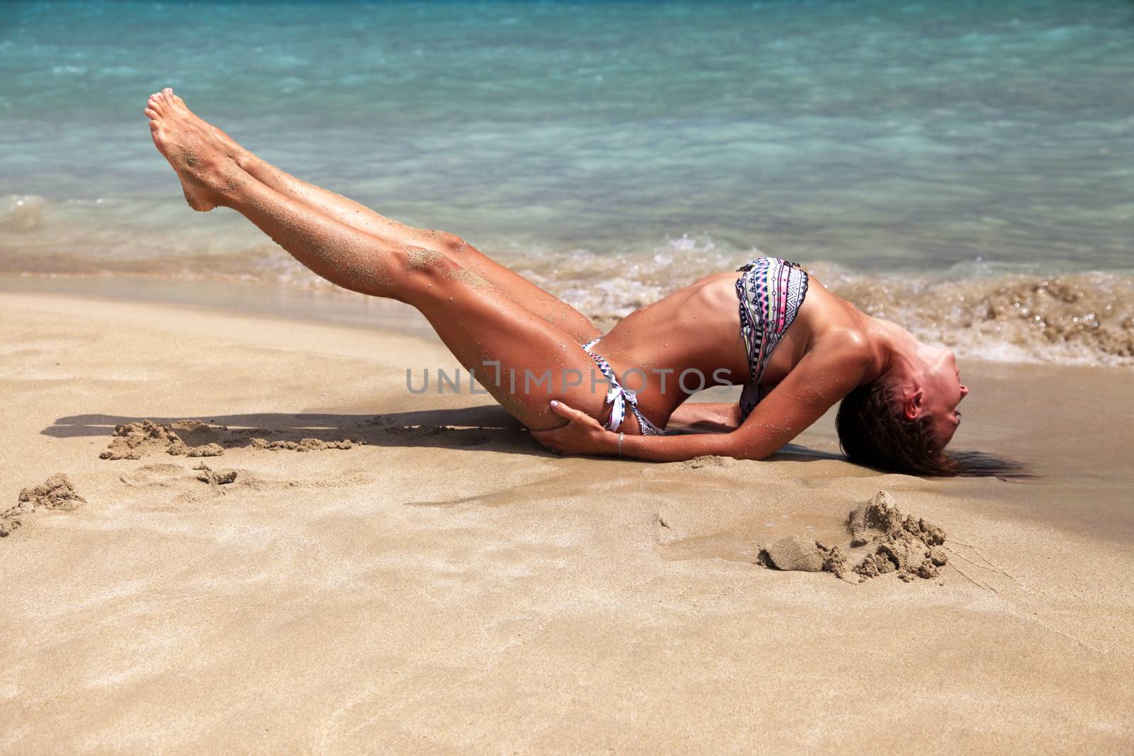 Caucasian woman practicing yoga at seashore