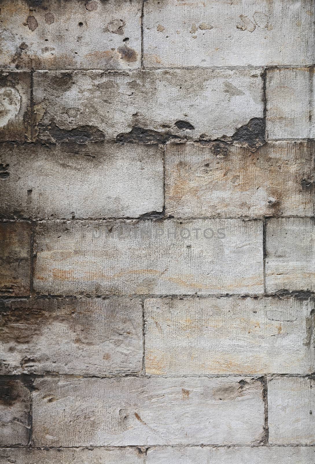 Wall of white and gray weathered grunge limestone travertine stone brick blocks, close up background texture, side view