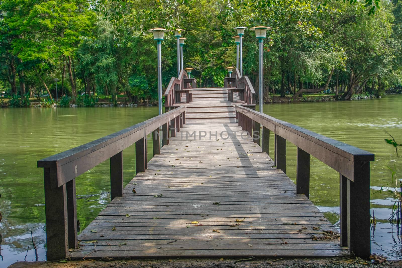walkway wooden bridge over pond on park of silpakorn university, Nakhonpathom