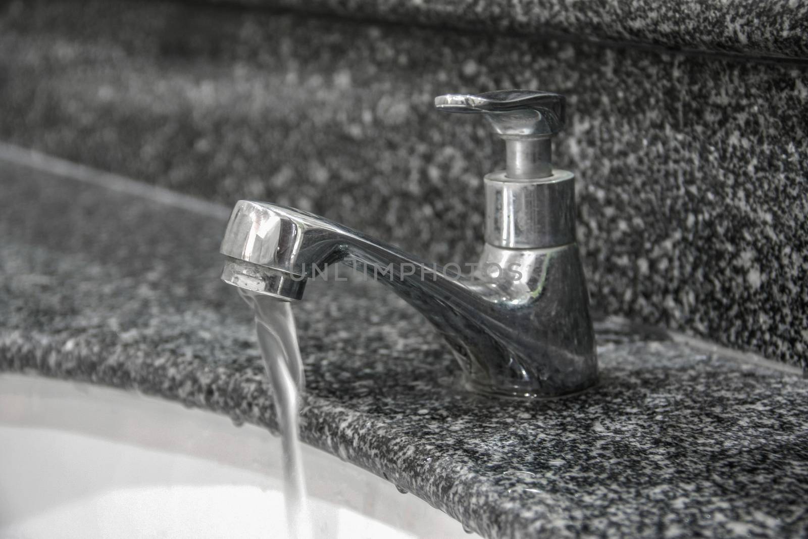 modern style faucet on granite tile with water drop in basin, wash hand