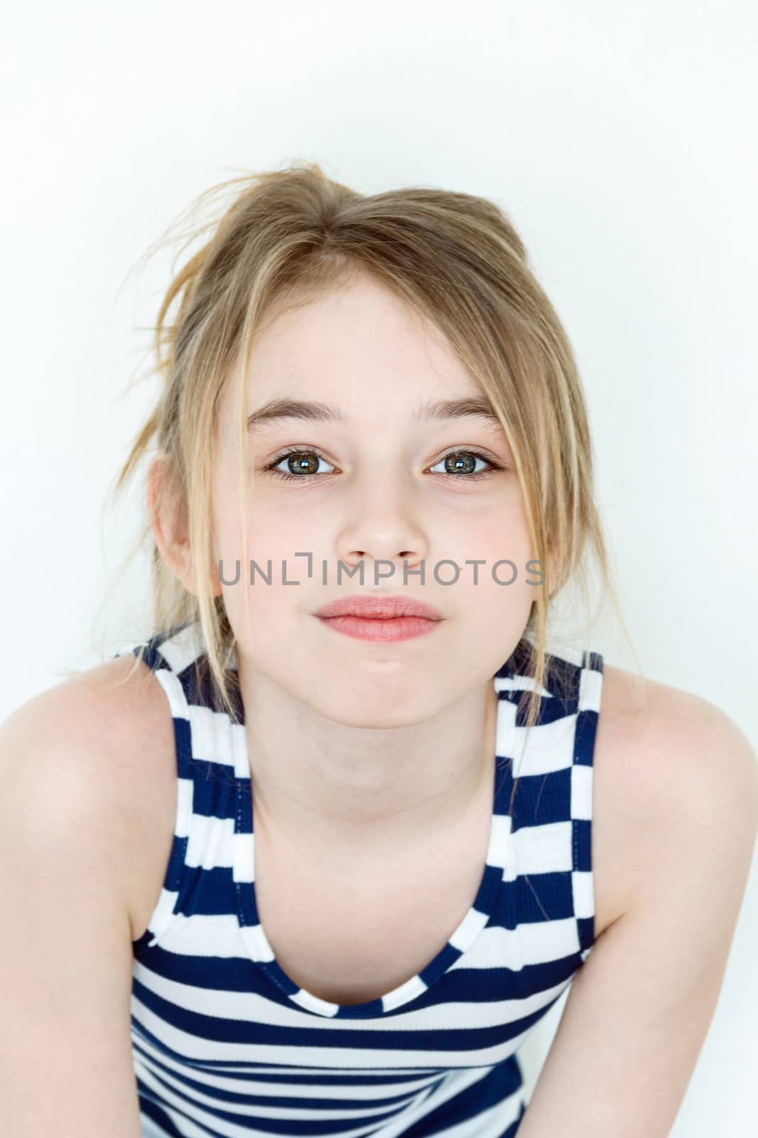 Close portrait of girl eleven years old with big green eyes on white