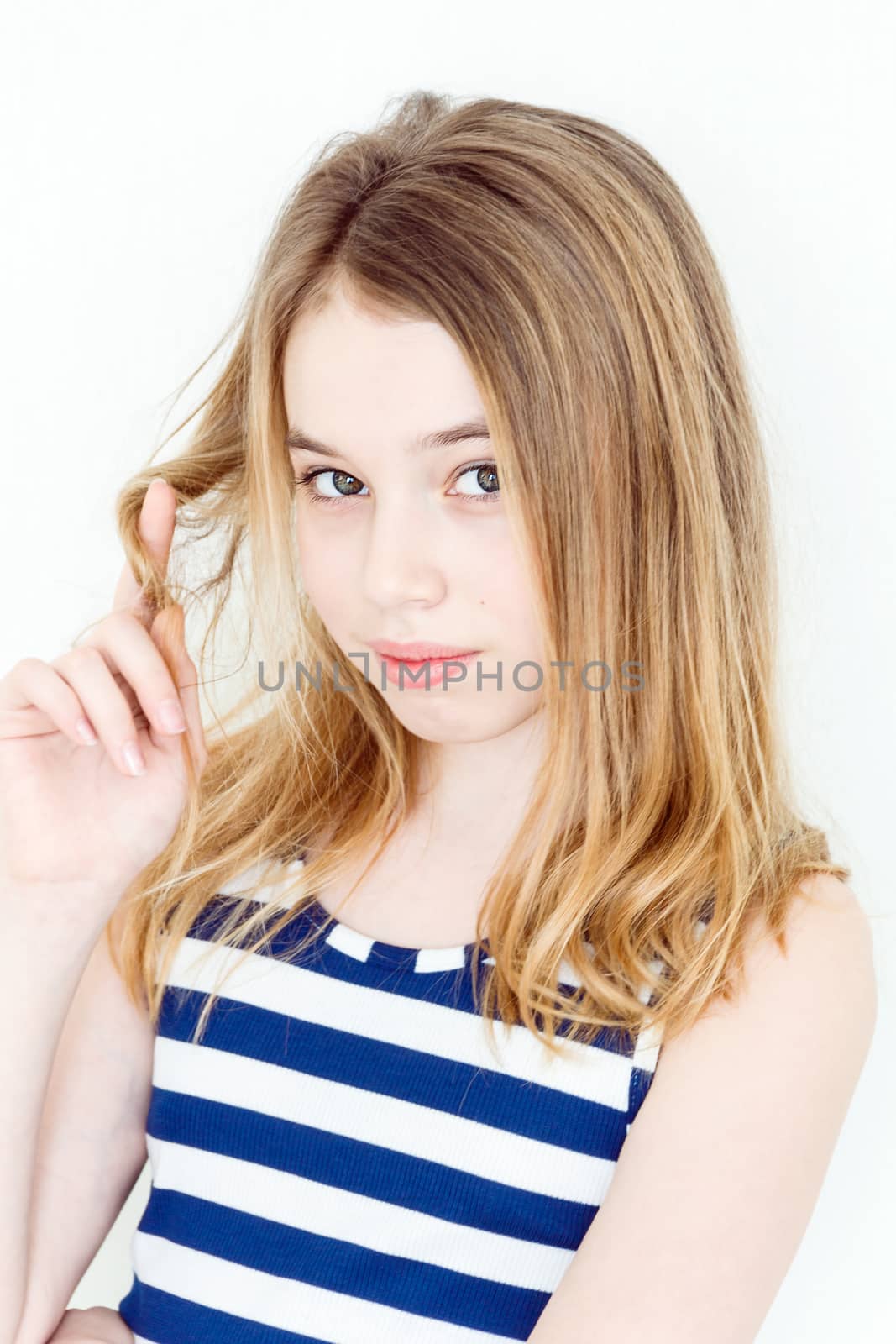 Cute blond girl winging hair on the finger
