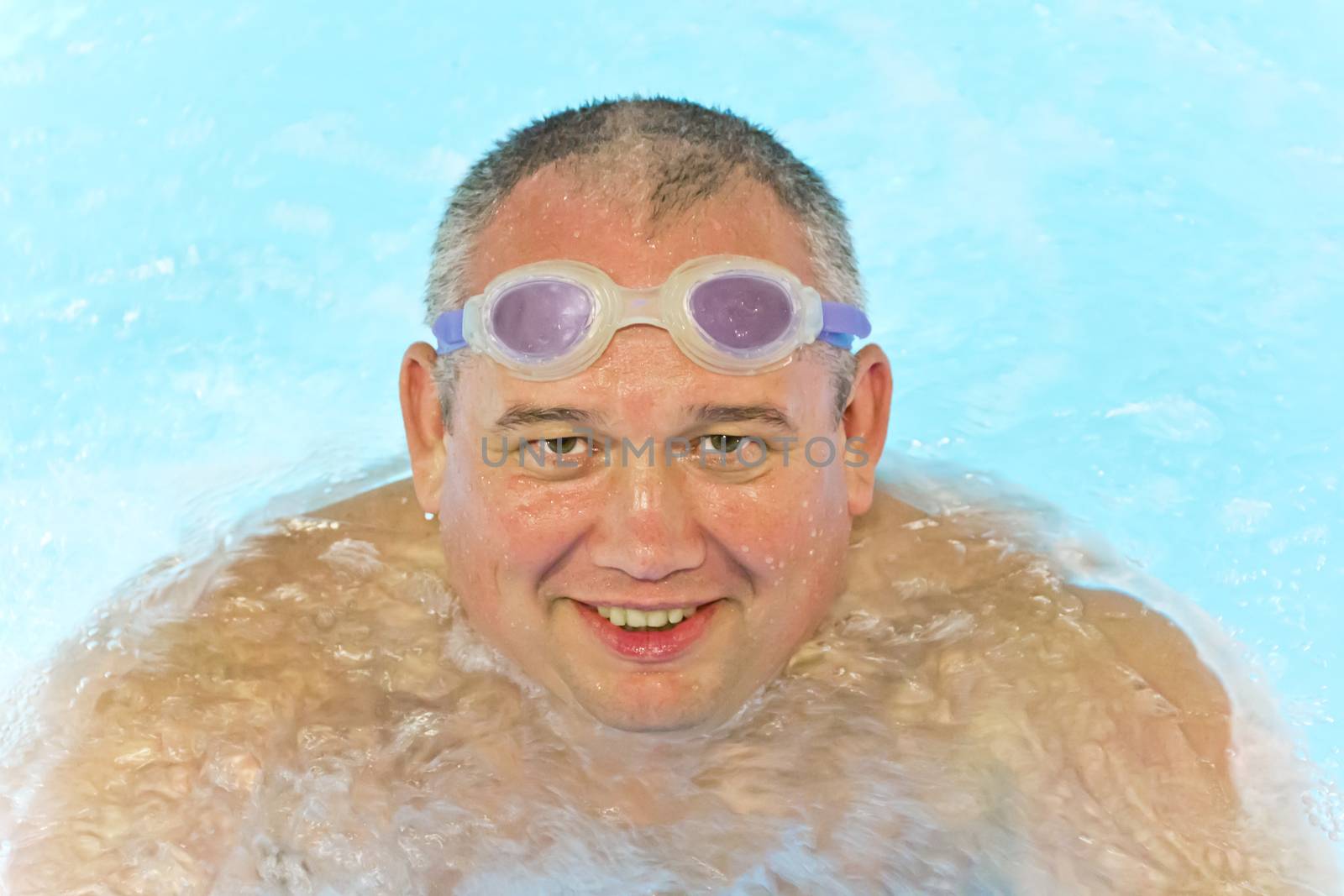 Portrait of big fat smiling man in swimming pool water