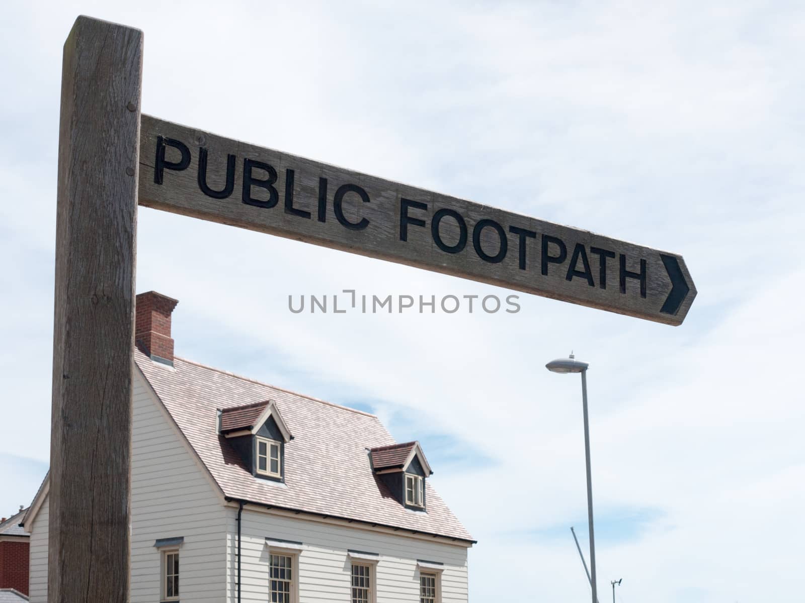 wooden post in town saying public footpath