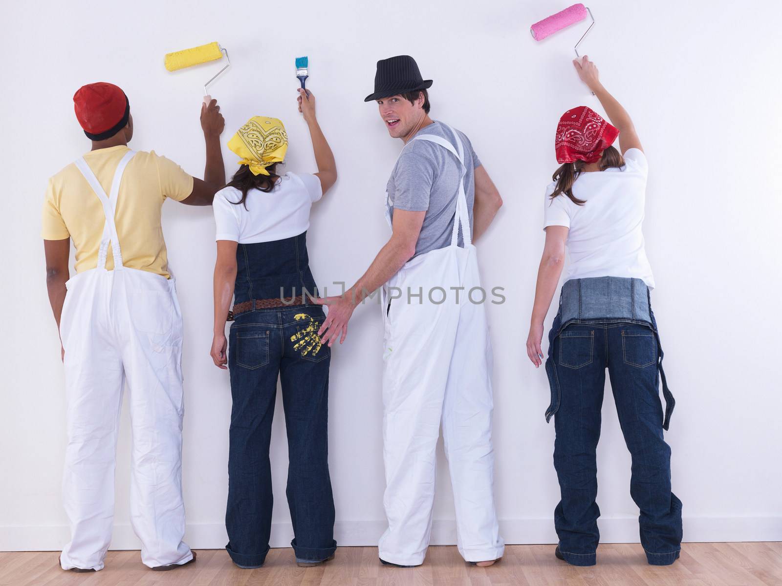 Group of friends about to paint wall.