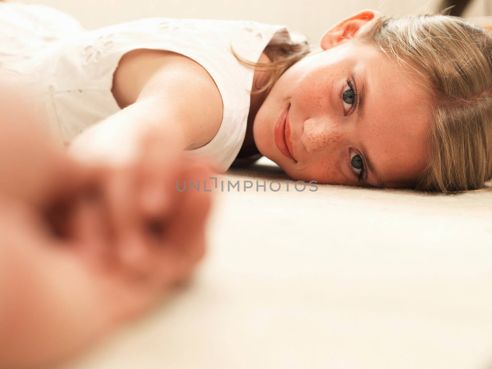 Girl smiling, resting head on floor
