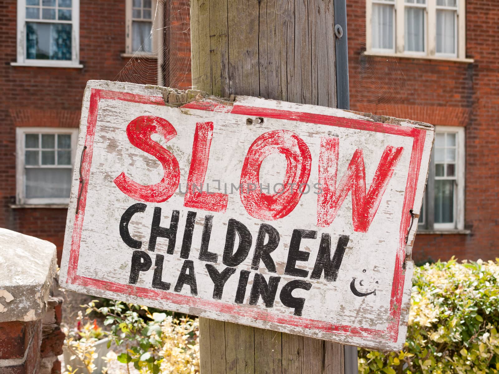 handmade unique red, black and white slow children playing sign on post outside