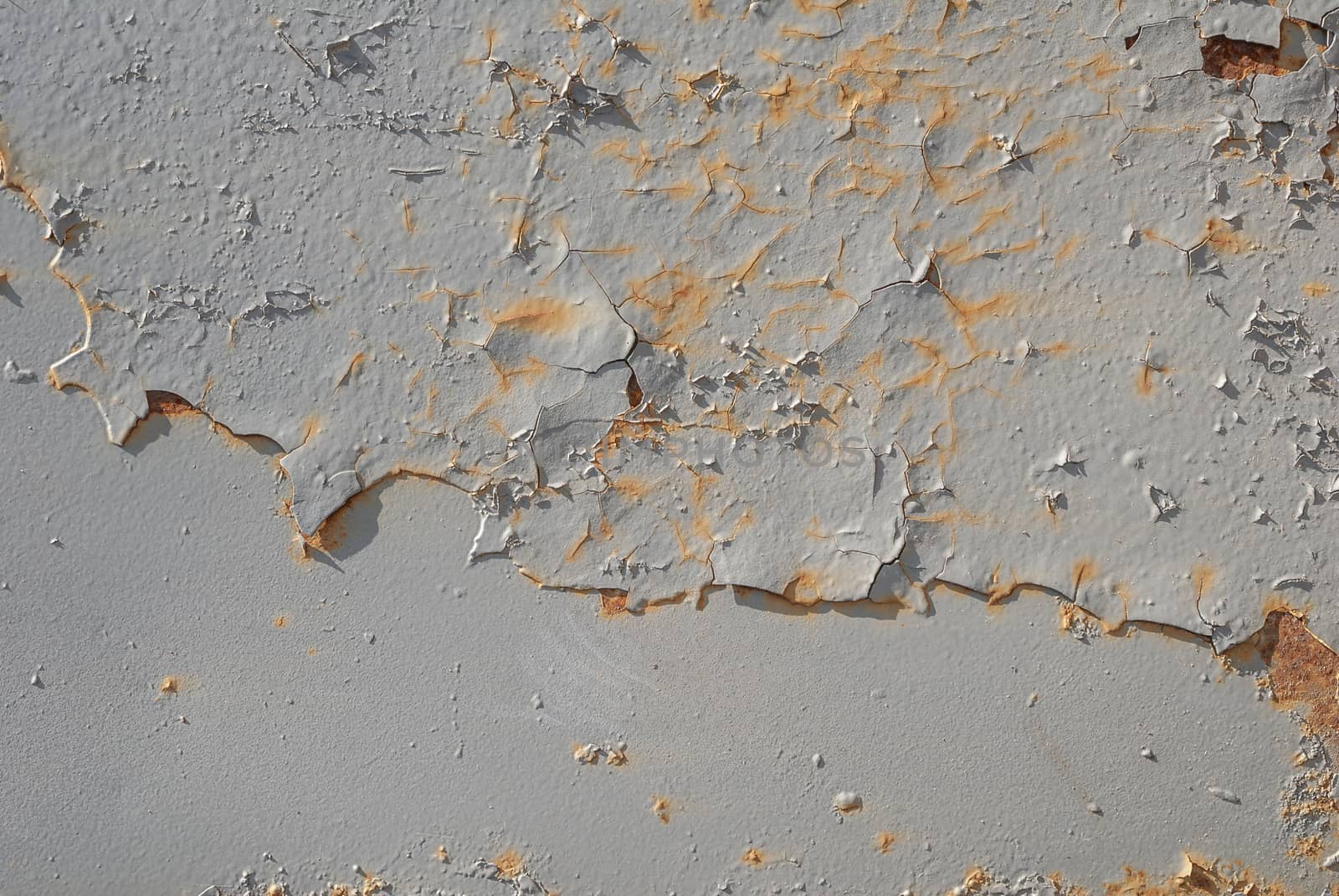 fragment of an iron surface is covered with grey color paint, which has long been under the influence of different climatic conditions