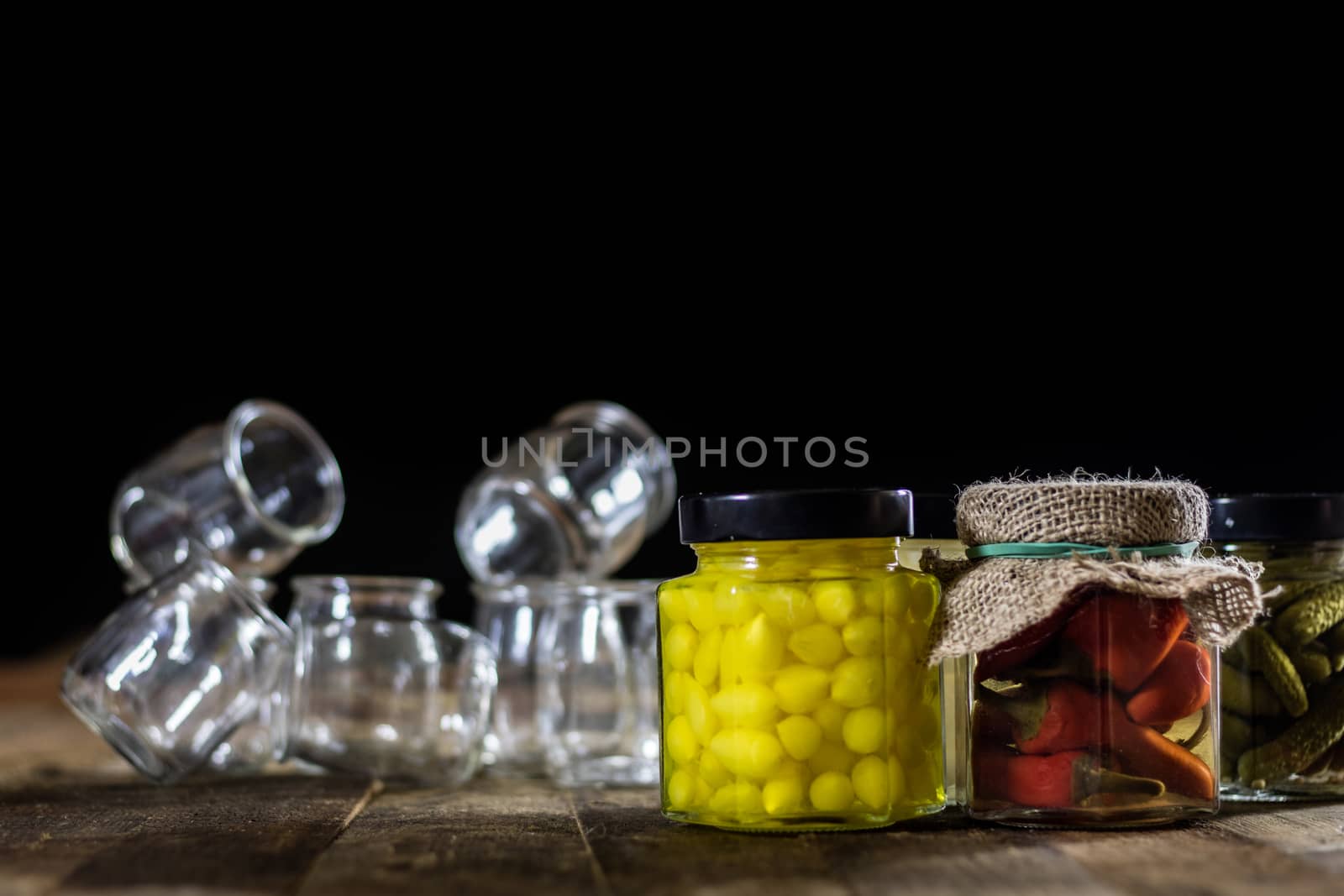 Mortar on a wooden table and empty jars, black background