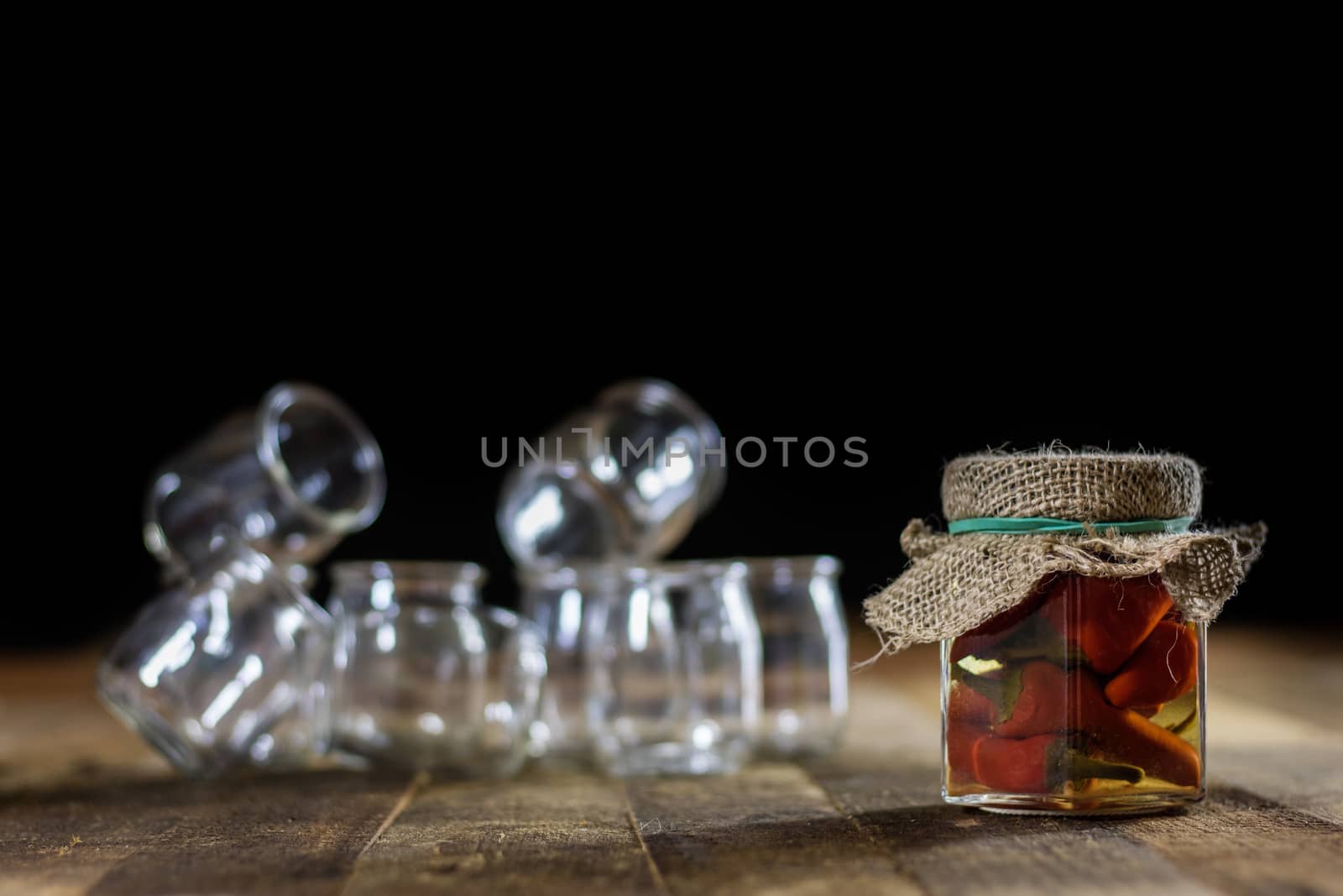 Mortar on a wooden table and empty jars, black background