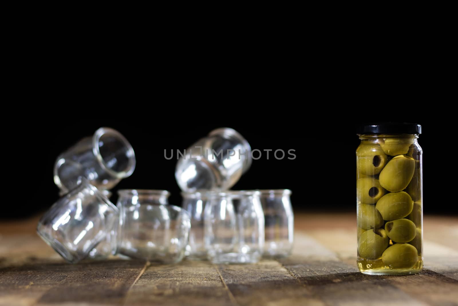 Mortar on a wooden table and empty jars, black background