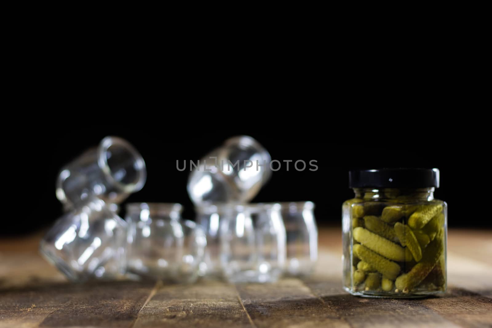 Mortar on a wooden table and empty jars, black background