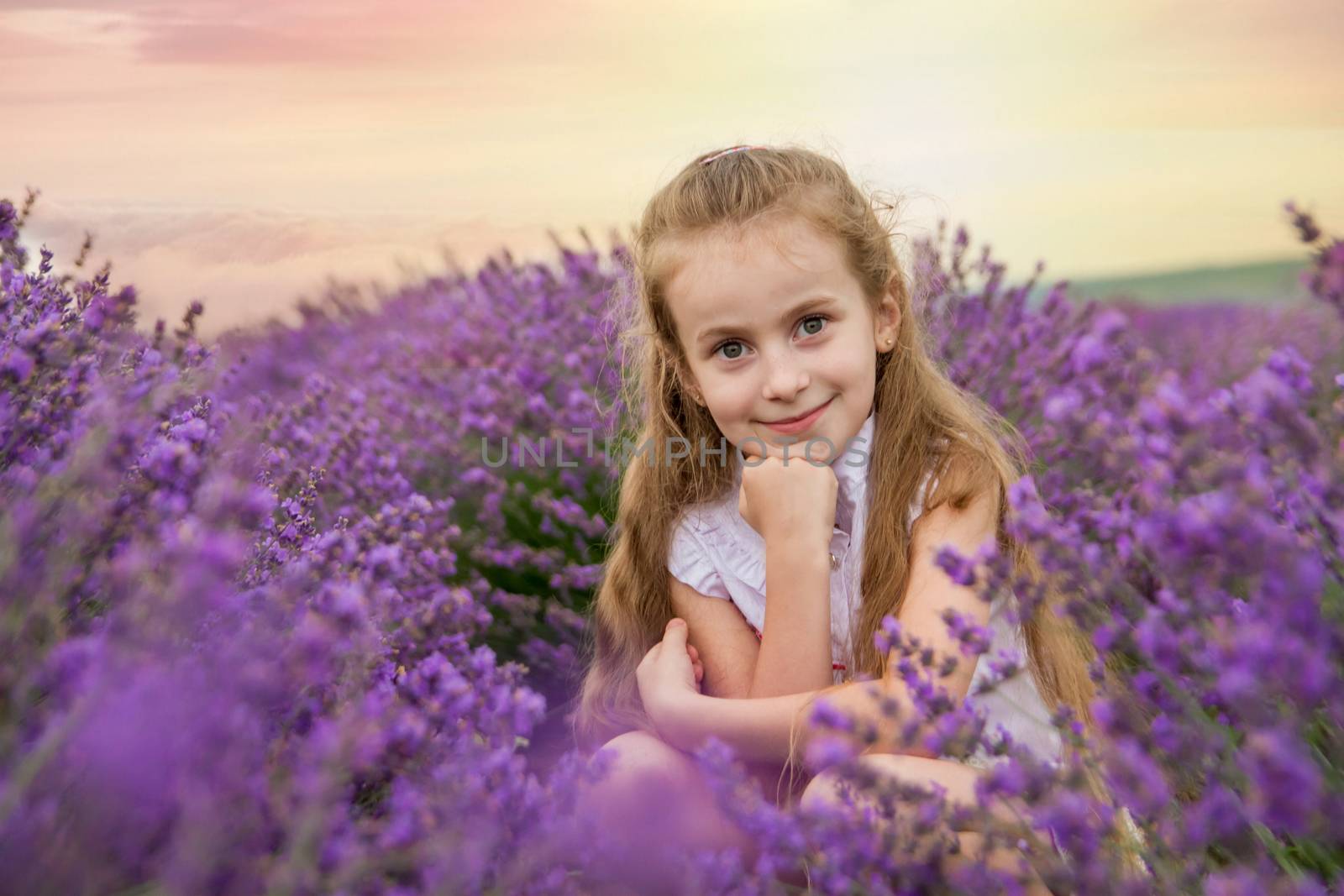 Cute girl in lavender field at sunset