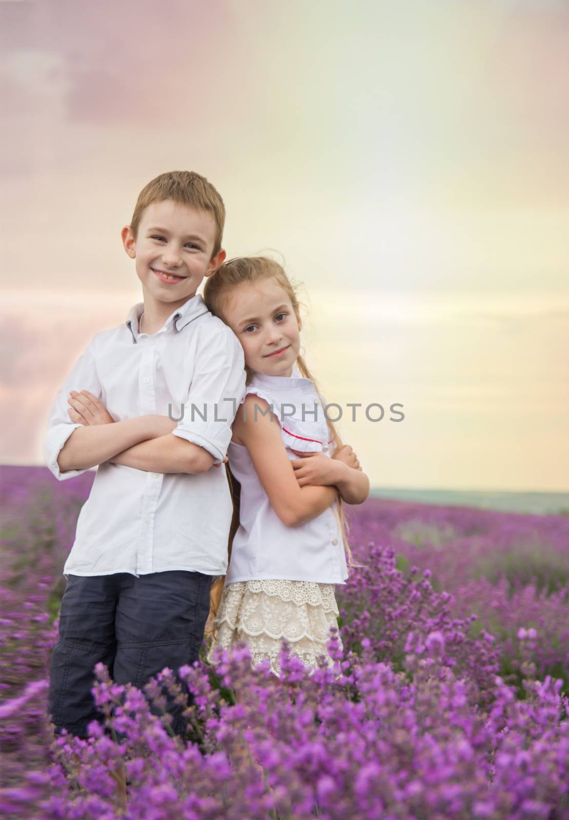 Happy brother and sister in lavender summer field back-to-back