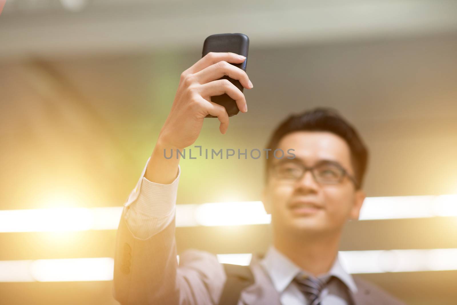 Business people taking selfie using smart phone, bright neon light background.