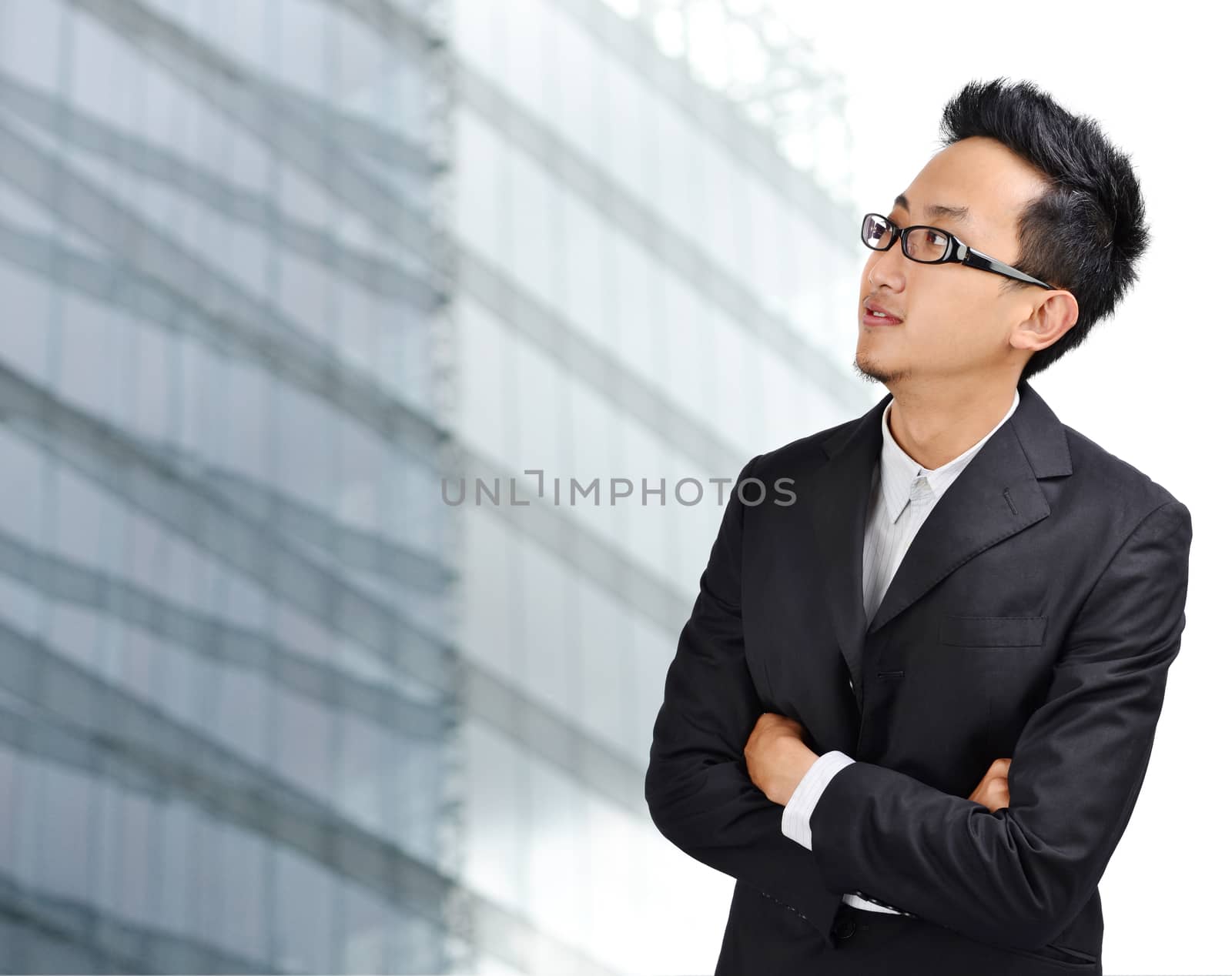 Young Asian man looking outside through windows